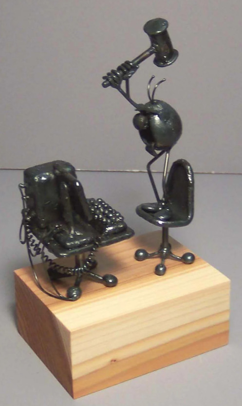 A tiny wooden desktop computer model with mallet — retro miniature art piece that nods to early computing in a totally charming way.