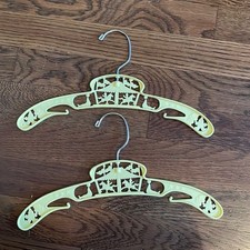 2 yellow plastic vintage child's clothing hangers with circus theme