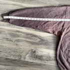 Brown vintage Nike sweatshirt with white swoosh, faded crewneck, and long sleeves, shown on wooden floor.