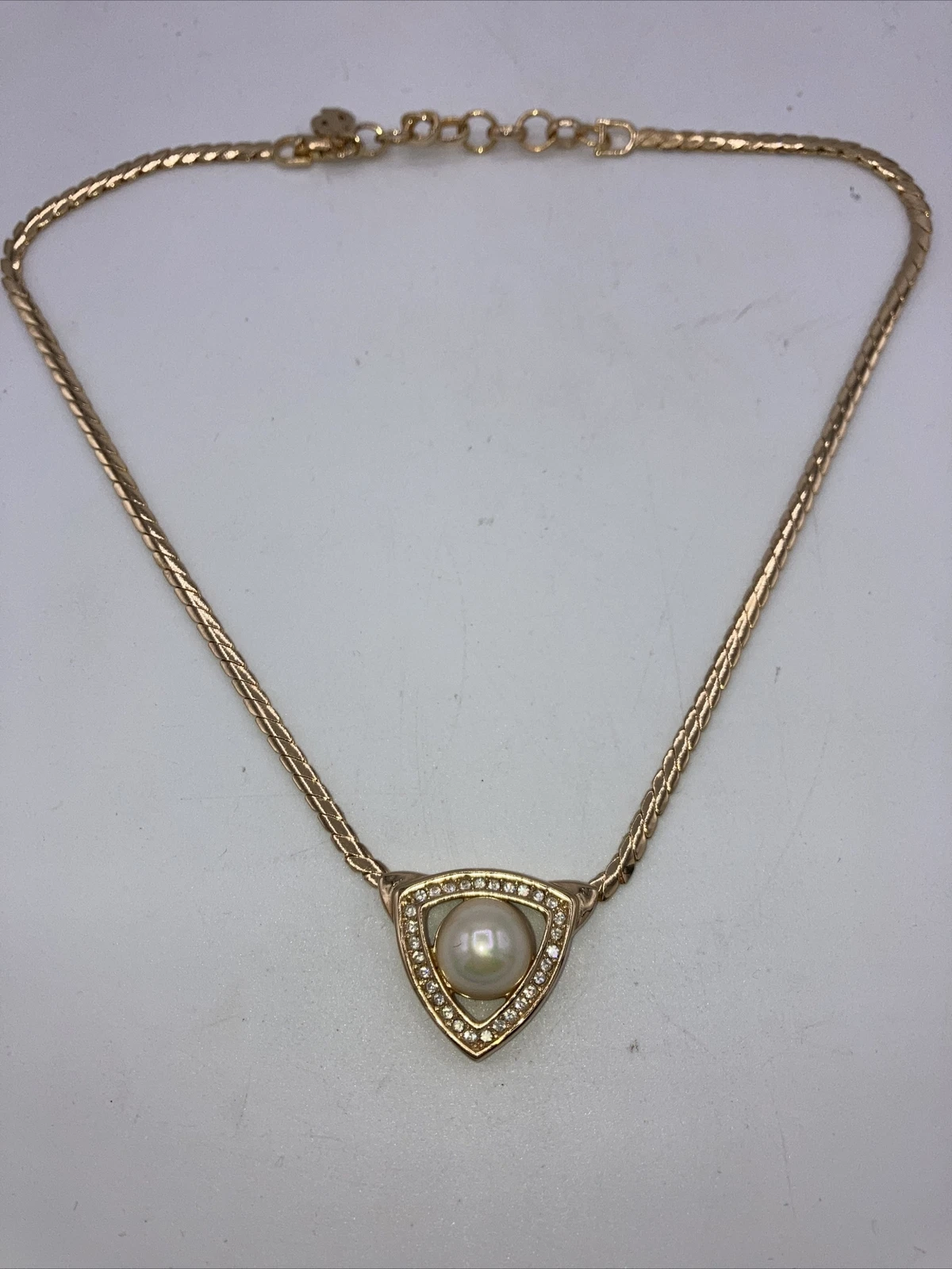 Collier Christian Dior Vintage. Ton or, strass en forme de V avec perle