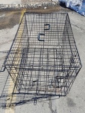black metal wire pet crate, often used for training or containing dogs.
