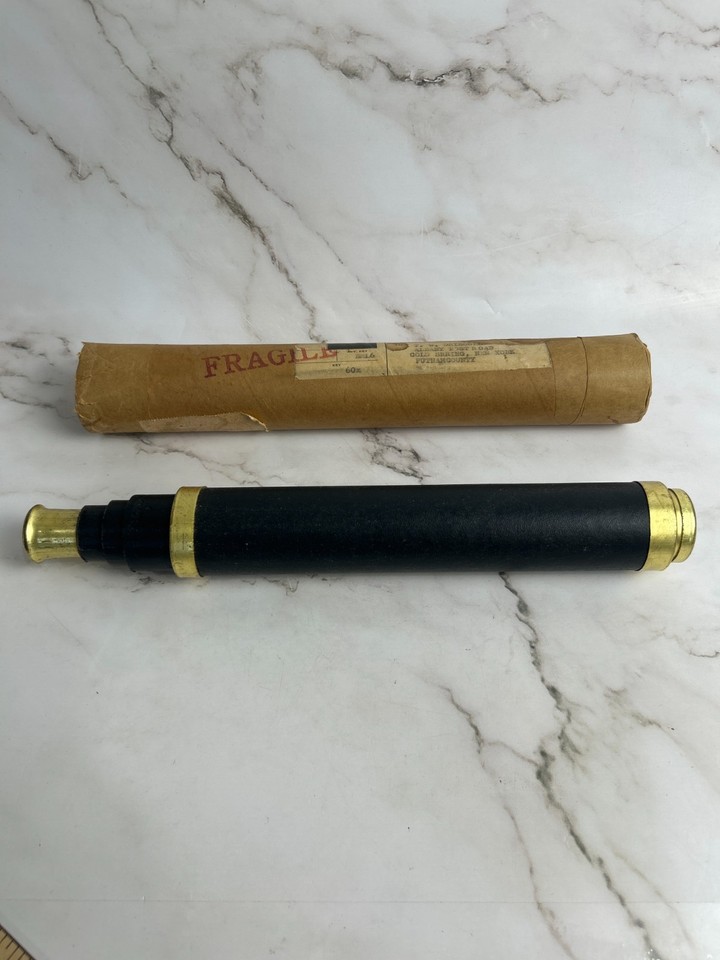 A 19th-century brass and leather maritime telescope in its original cardboard case — a piece of actual seafaring history you can hold in your hands.