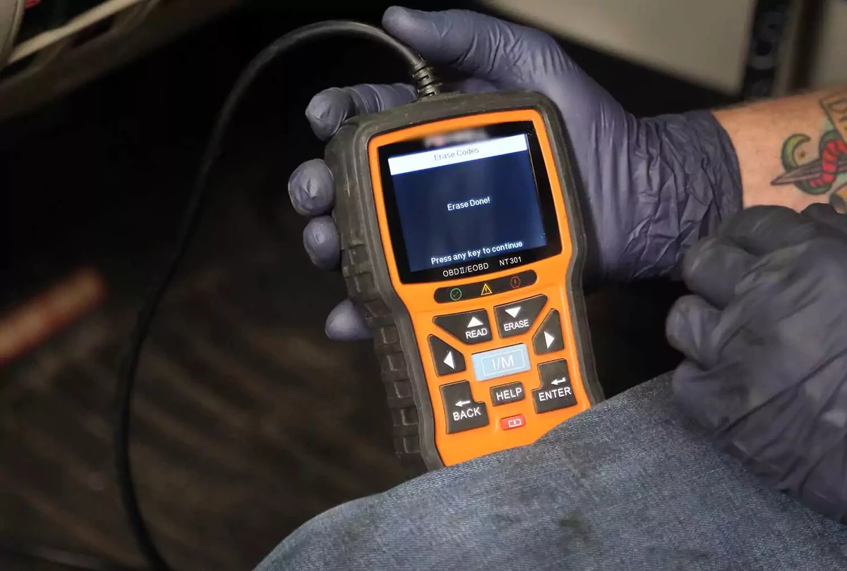 An OBDII scanner erasing codes while being held by hand.