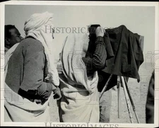 1965 Press Photo Tribesmen Marvel at Camera on Tripod in Sahara Desert