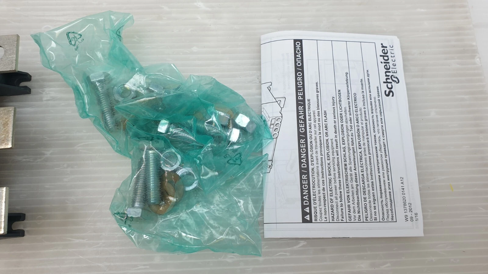 Bag of bolts, nuts and washers with the Schneider instruction sheet for the LR9F relay