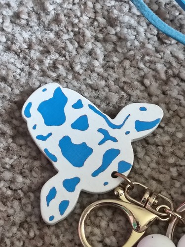 BRACCIALE PORTACHIAVI PERLINE SILICONE BIANCO E BLU CON CIONDOLO MUCCA E NAPPA BLU - Foto 2 di 3