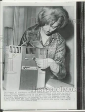 1967 Press Photo Woman turns the key to portable electronic watchdog in London