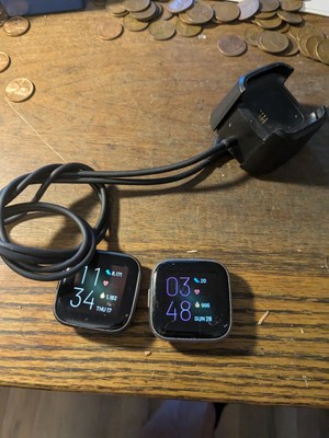 Two Fitbit Watches Without Bands Plus Charger First Versa One And Two
