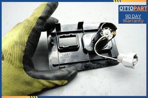 Black 2007-2012 Lexus LS460 LS460L center console auxiliary adapter with blue text label and yellow gloves.