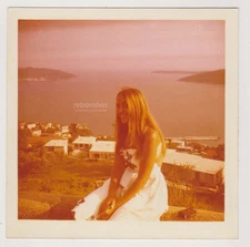 Charming Blonde Young Woman In White Dress Sitting By The Sea Vintage Snapshot