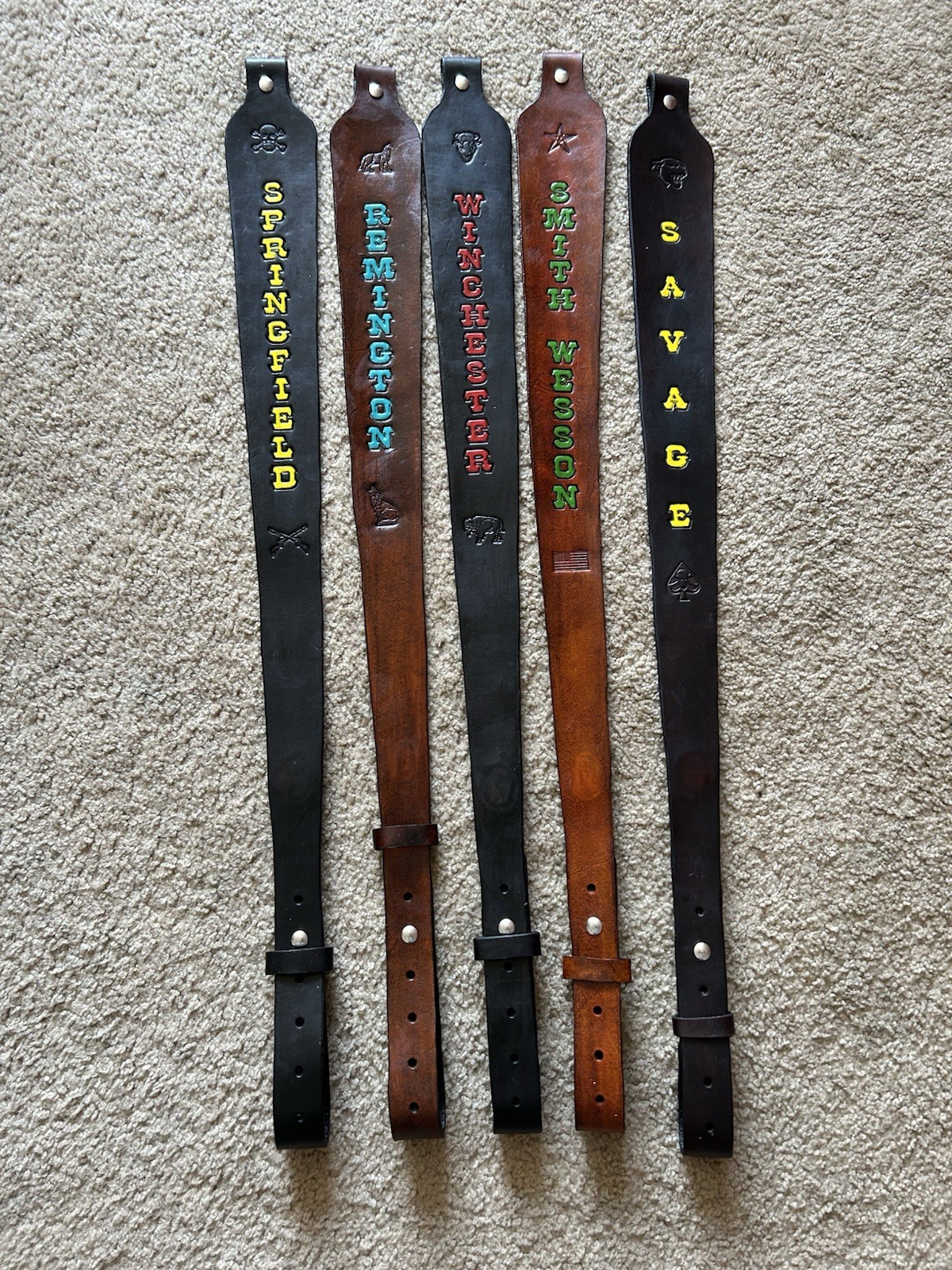 Brown leather rifle sling with black panels, gold “SPRINGFIELD,” and “SAVAGE” text.