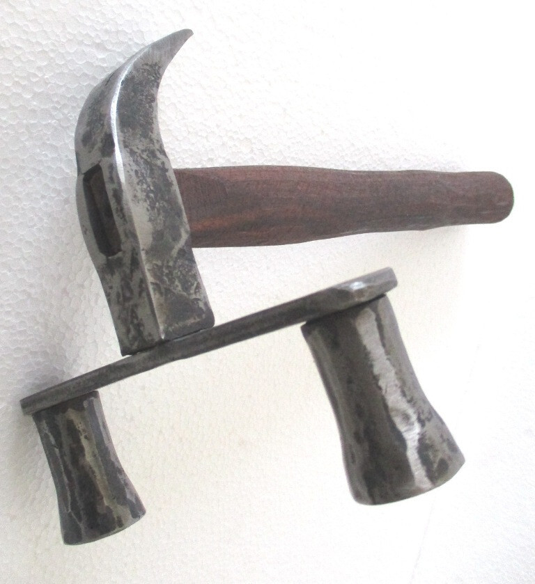 A double-headed hammer with twin claws is the kind of gnarly antique tool that looks like it belongs in a blacksmith's museum — pure conversation piece.