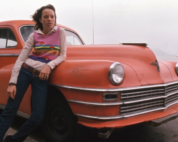 Mackenzie Phillips poses with orange Chrysler car American