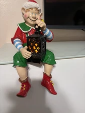 Shelf Or Mantle Sitting Happy Christmas Elf With Flickering Flameless Lamplight