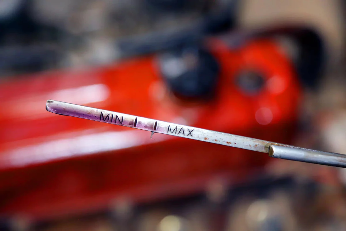 An engine oil dipstick indicating the oil near the maximum level.