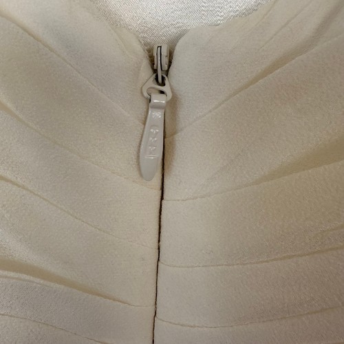 Silver zipper with chain detail on ivory silk wedding dress made in USA, shown on close-up of textured bodice.