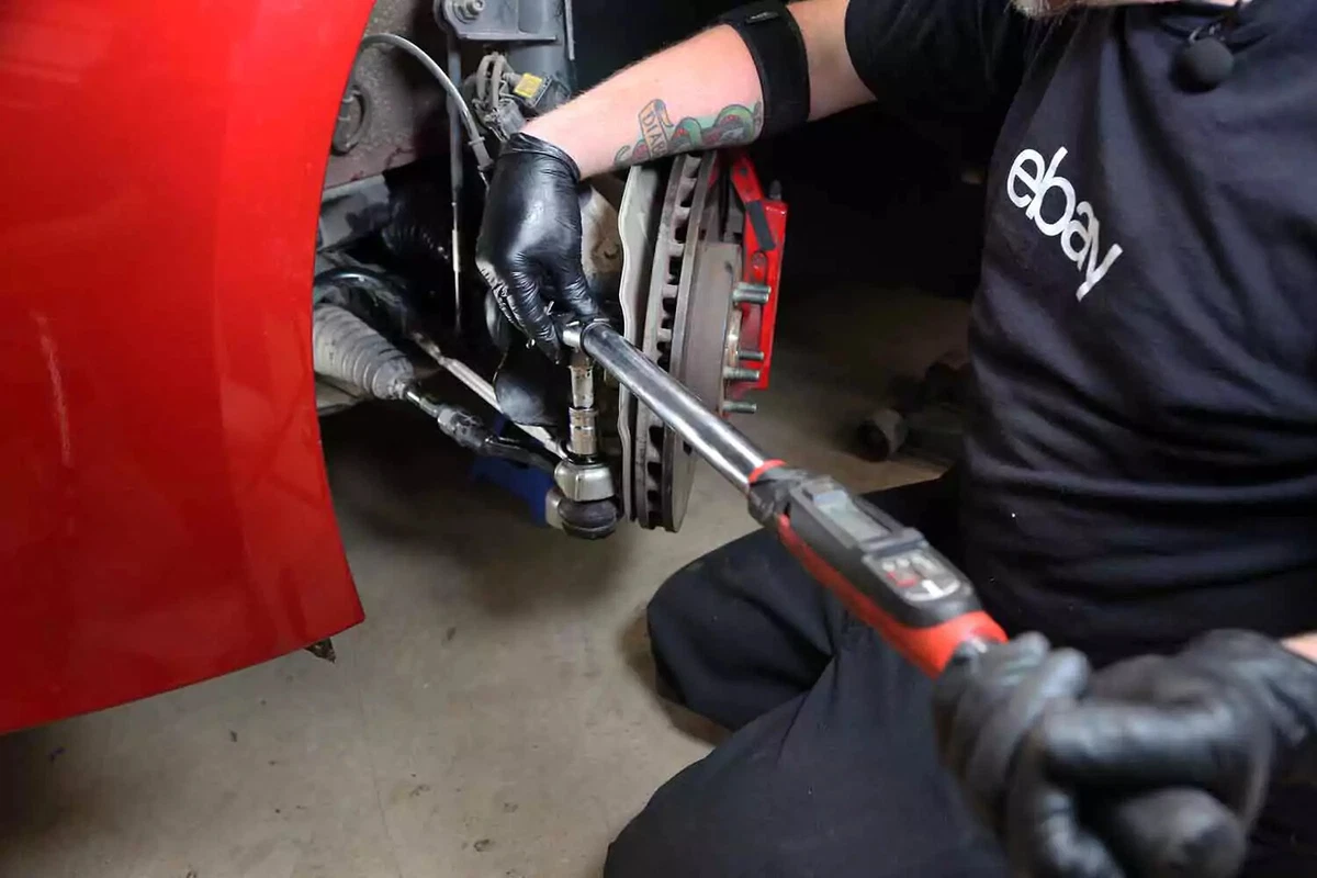 A mechanic uses a torque wrench to tighten the castle nut to factory specifications.