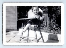 Foto antigua vintage niño sonriente sentado en silla alta instantánea antigua