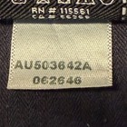 White fabric tag on black 7 For All Mankind denim shorts, size 32, with gray printed code “AU503642A 027264B” and product details.