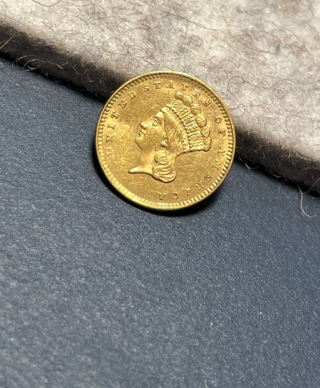 (#101879) Gold Dollar:  1857.  Type 3. princess head.  Unc, bent  (see video!)