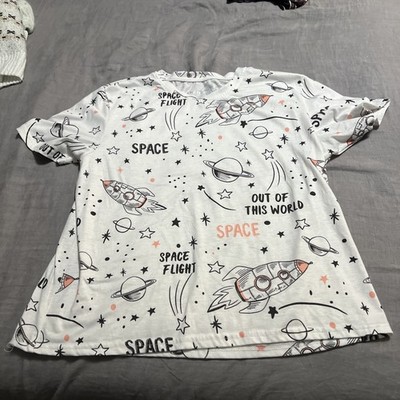 white t-shirt featuring an all-over space print with rockets, planets, stars