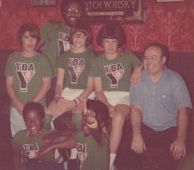 Group of Six Youth in Matching Green YBA Shirts Bar Setting Red Wallpaper
