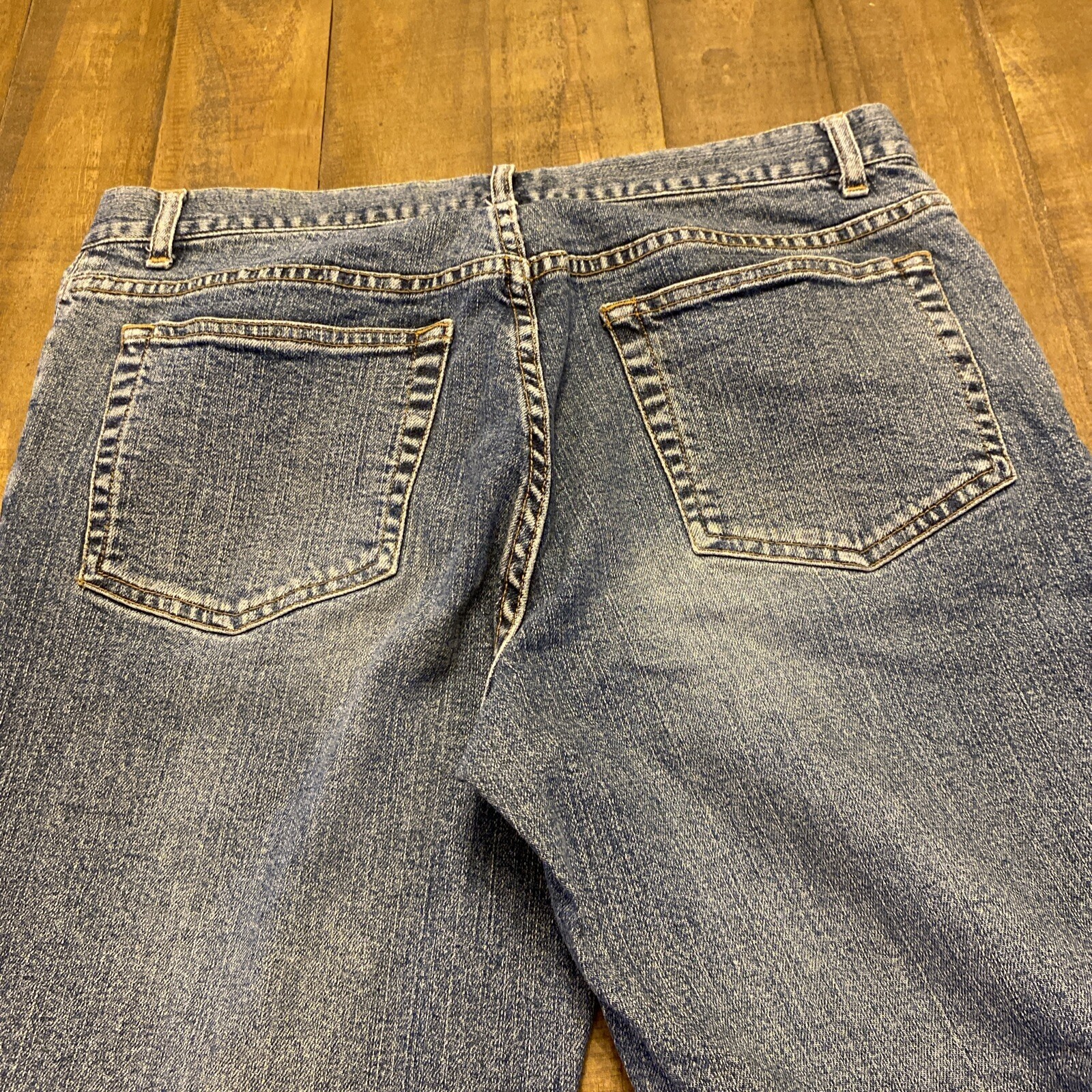 Blue Theory jeans men’s 30x33 with button fly closure, back pockets, and faded stretch denim design on light wood floor.