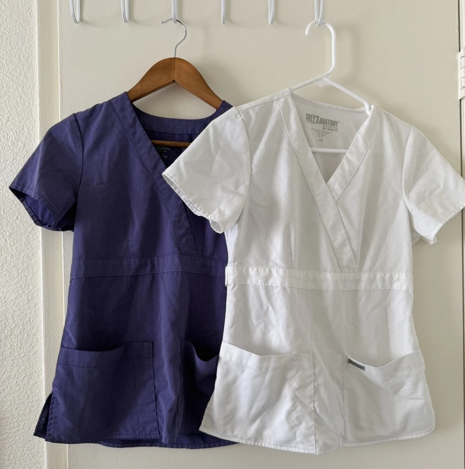 Paquete de dos camisetas exfoliantes para mujer Grey’s Anatomy by Barco talla XS blancas moradas Foto 2 de 4