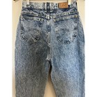Back view of 90s vintage Lee High Rise Mom Jeans in blue distressed denim with two pockets and brown leather patch on waistband.
