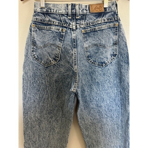 Back view of 90s vintage Lee High Rise Mom Jeans in blue distressed denim with two pockets and brown leather patch on waistband.