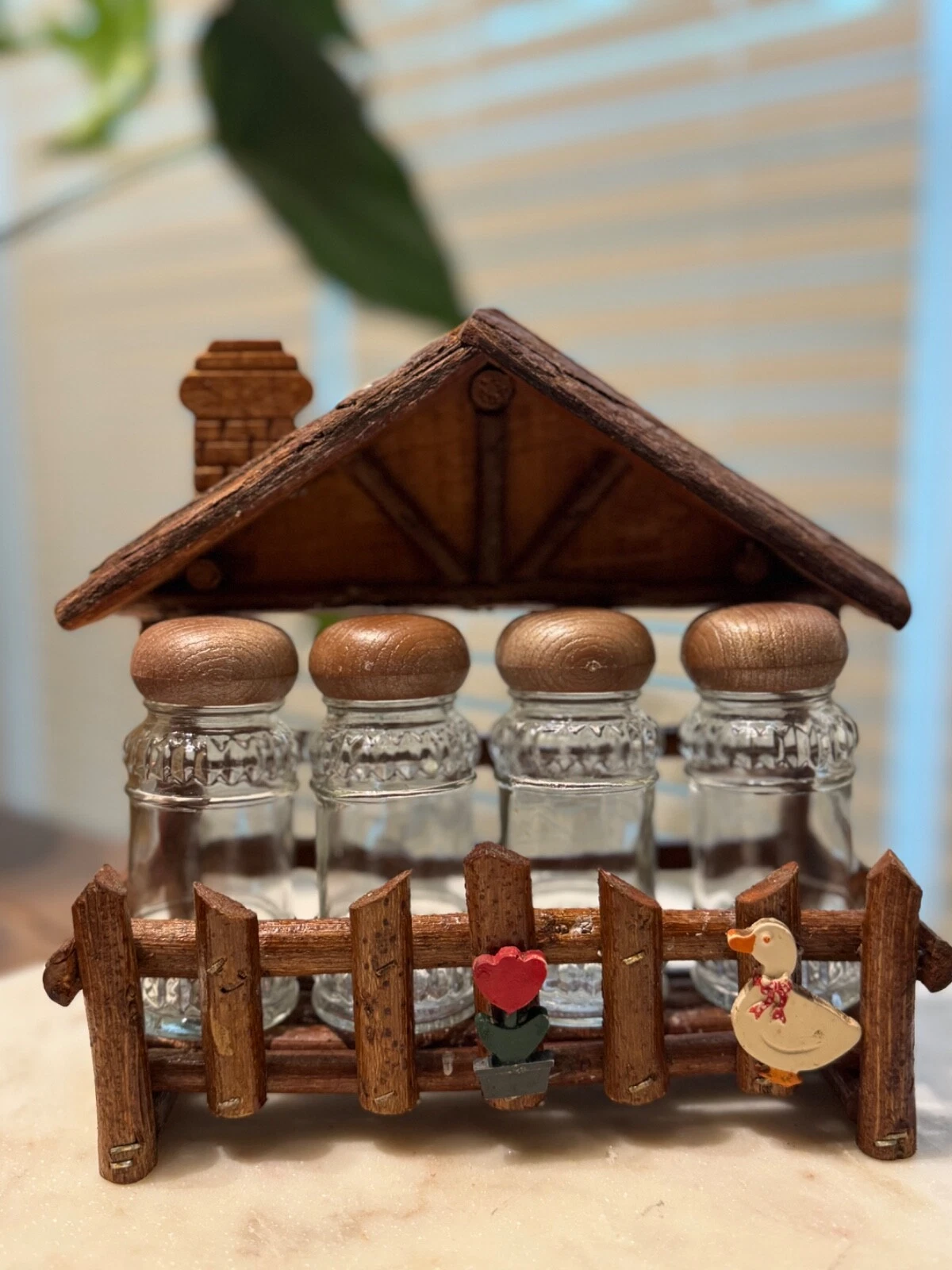 Vintage spice rack with four spice jars featuring white goose and flower