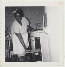 1955 PHOTO OF AFRICAN-AMERICAN WOMAN PUTTING BROWNIE BALL IN OVEN