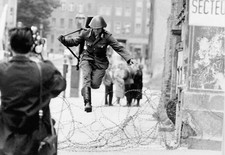 EASTGERMAN GUARD JUMPSBARBED WIRE TO FREED. Photo