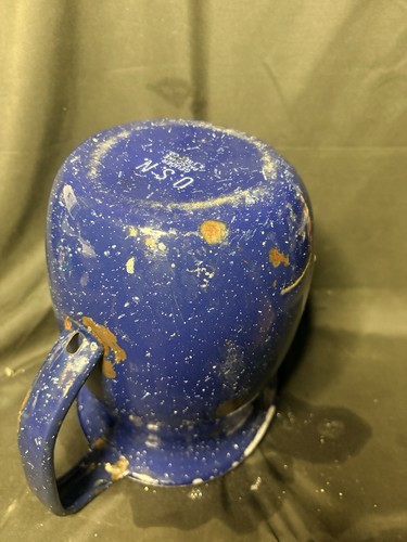 Wartime blue enamel granite pitcher with tan interior, worn white patches, and visible “U.S.N.” markings on side.