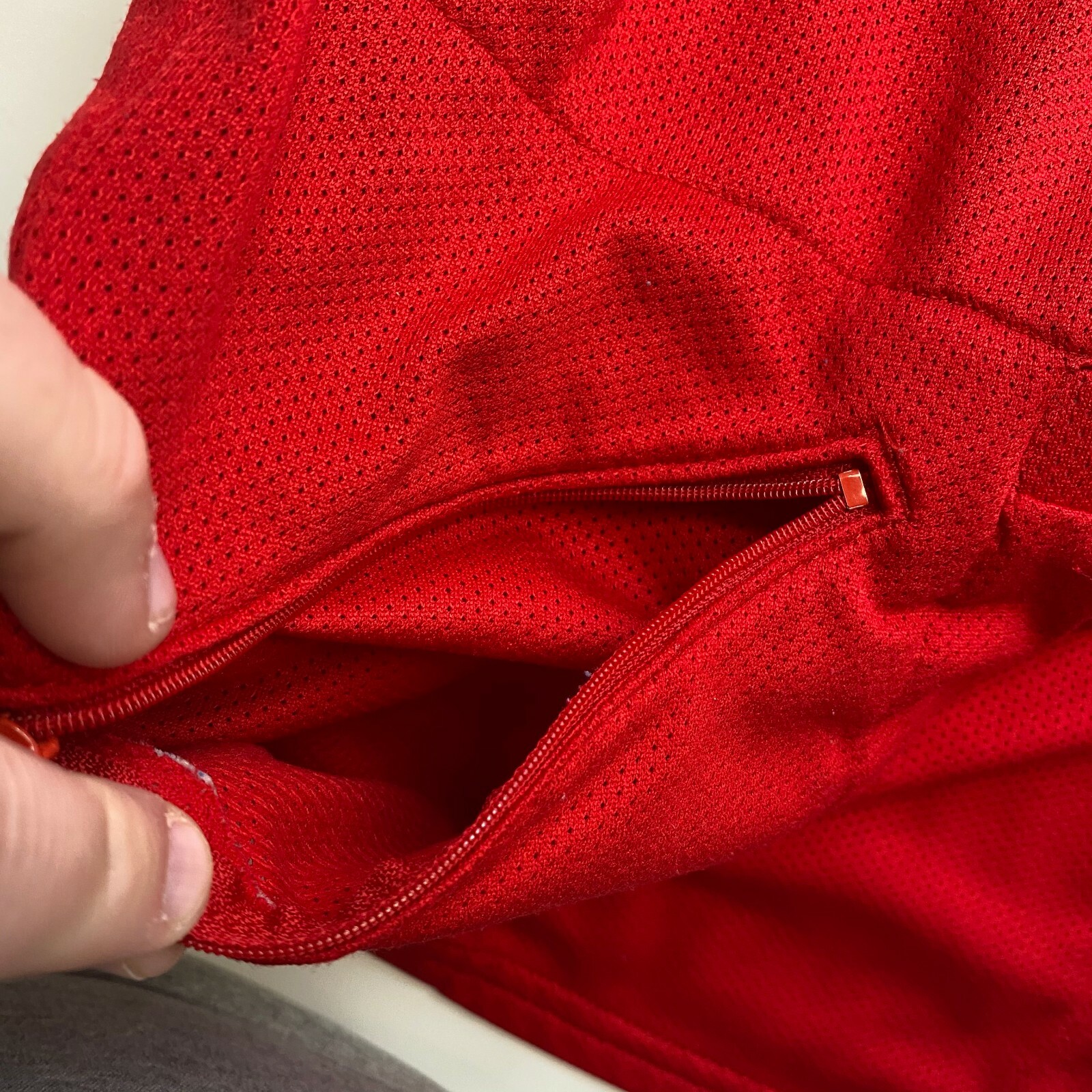 Red mesh Izumi men’s cycle shirt with half zip, front pocket, and red zipper, made in USA.