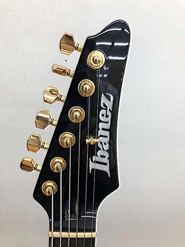 Black Ibanez AZ47P2K Dragoneyeburst electric guitar head with gold hardware and six tuning pegs on a light background.