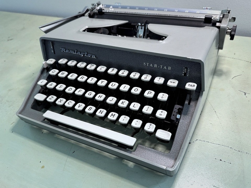 A professionally serviced 1960s Remington Star-Tab in cool light gray with its original case — ready to type and ready to display.