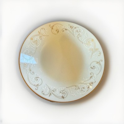 Noritake Duetto #6610 bread plate with gold scrolls and a white center.