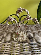 gold-toned metal jewelry stand decorated with small flowers and red glass gem