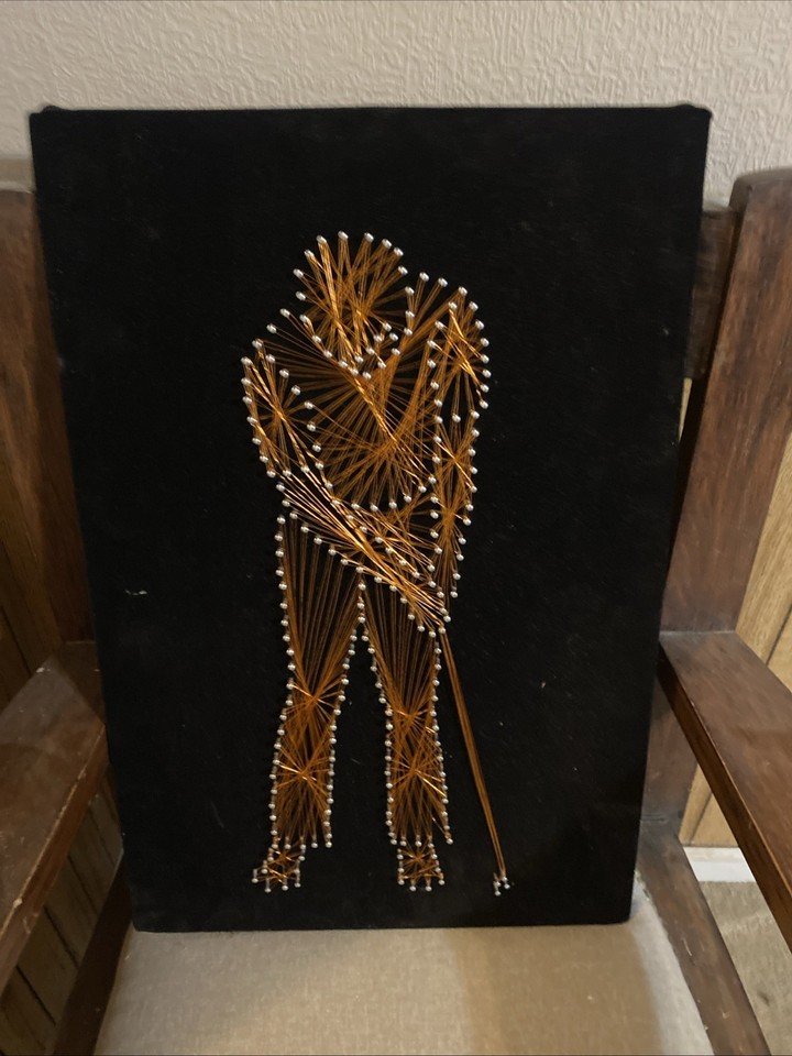 Mid-century modern string art golfer on black velvet with copper wire — a gloriously niche, handcrafted op-art piece that's a guaranteed conversation starter.
