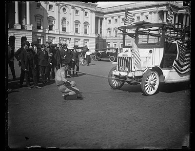 Photo:Man pulling bus with teeth outside U.S. Capitol, Washington, D.C.