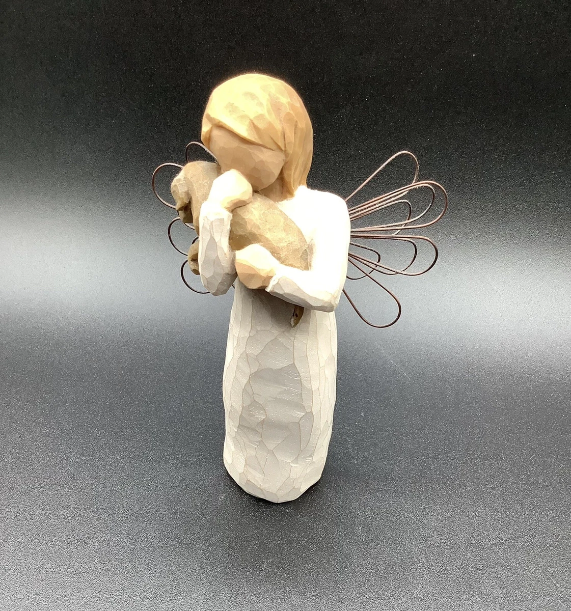 Angel holding top dog figurine