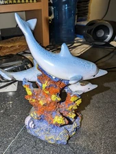 A Polystone of 3 Blue Dolphins swimming around coral