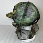 Green and brown camouflage Vtg hat with mesh front and dark green mosquito netting on the sides.