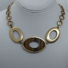 Xiomara Castro incrustación aspecto oro mate y piedra.