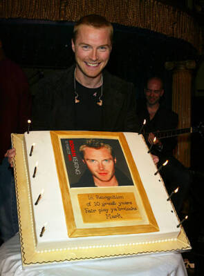 Ronan Keating stands behind a cake as he at the launch party to c- 2004 Photo 2