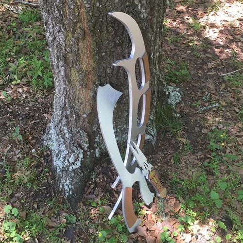 Klingon Bat’leth, Mek’Leth, and Dak’Tang dagger cosplay props with silver blades and brown handles in a wooded setting.