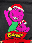 Purple Barney Christmas sweater with red Santa hat, green scarf, candy cane, and “Barney” text under knitted logo.