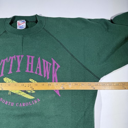 Green vintage Hanes Kitty Hawk sweatshirt with purple “Kitty Hawk North Carolina” text and yellow airplane graphic on chest.