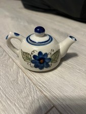 A mini tea pot with a flower design and removable lid, in good conditon